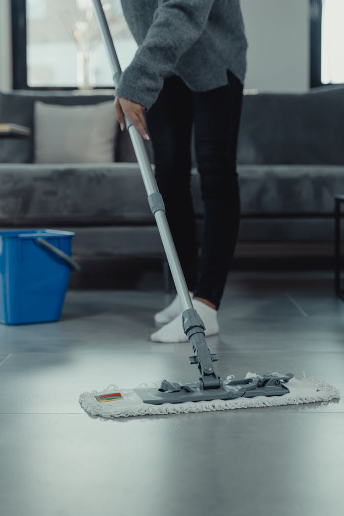 journey Close-up of person mopping a clean tile floor in a contemporary living room.